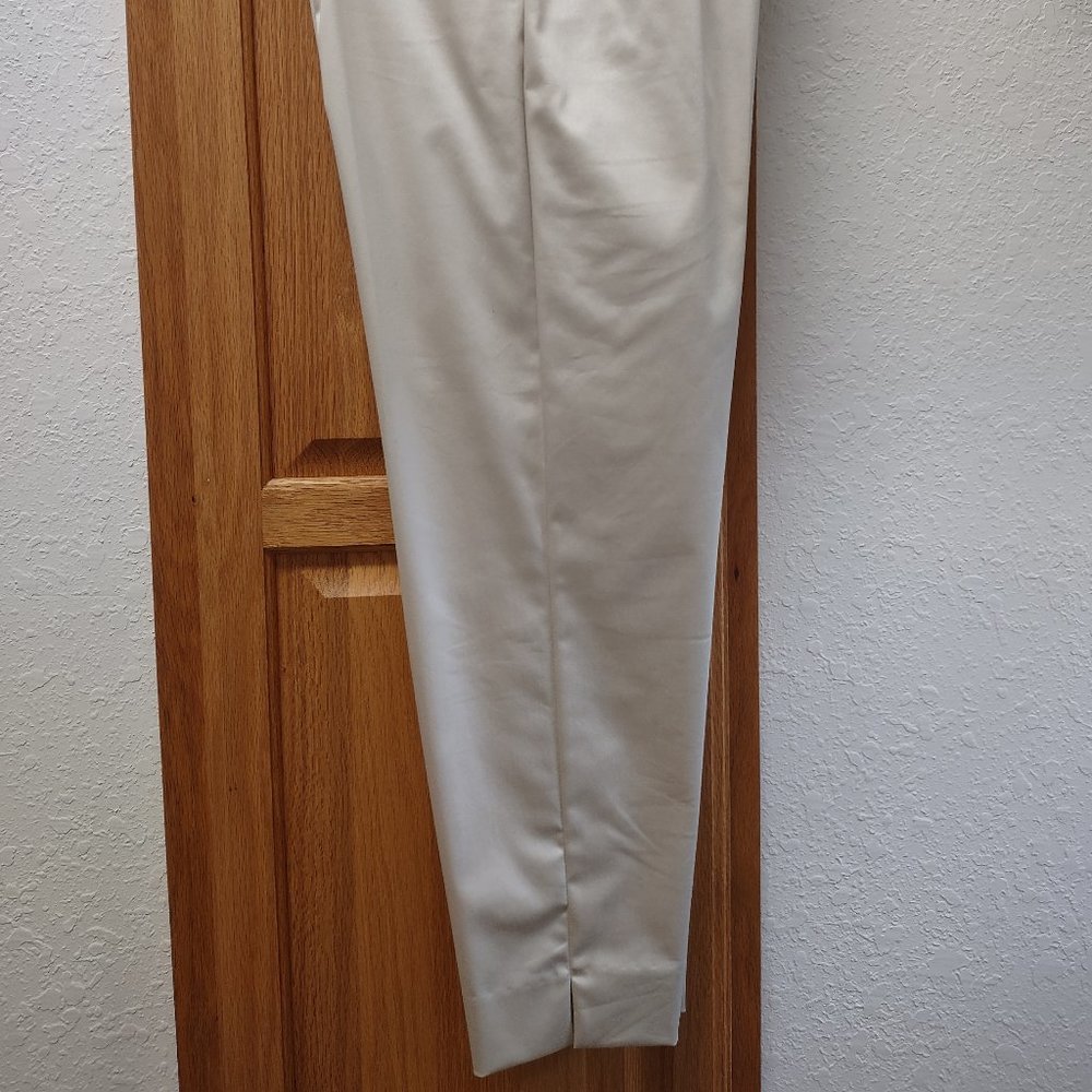 NWOT. Ladies stretch straight leg pant with slit ankle hem. Size 4, gold color.